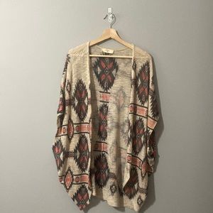 Ruana in a beautiful pattern, beige, gray and coral colors.